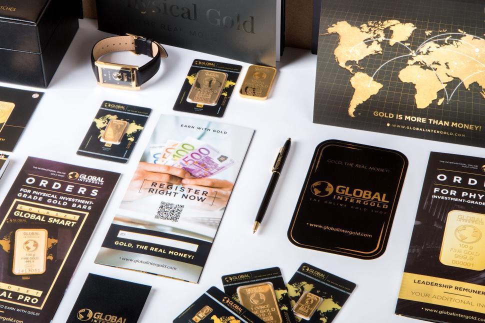 Free Image of Gold bars and marketing material on desk 