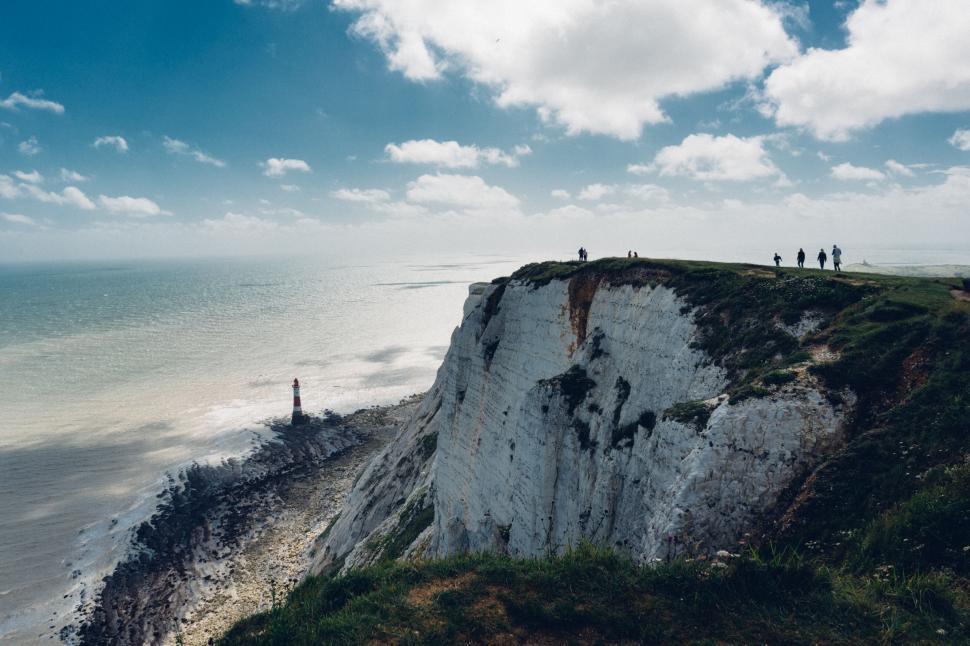 Free Image of Cliffside by the sea with people on top 