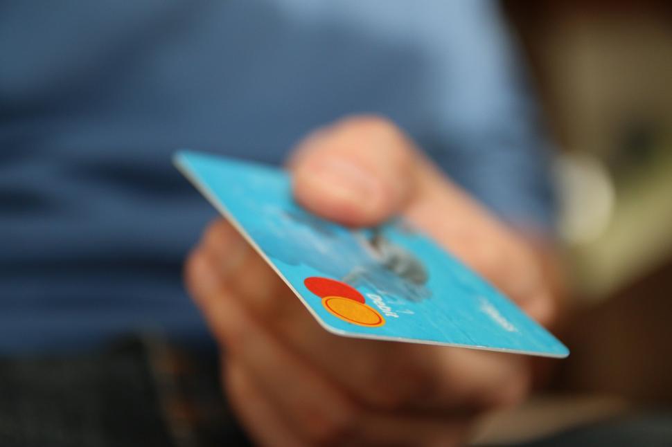 Free Image of Hand holding credit card closeup with blurry background 