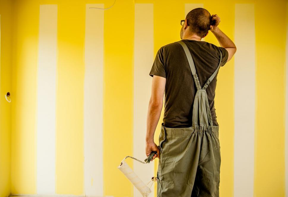 Free Image of Painter inspecting freshly painted wall 