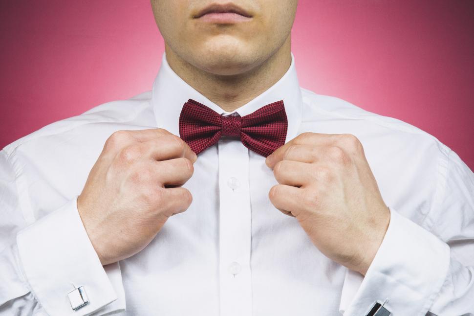 Free Image of Man adjusting red bow tie on his shirt 