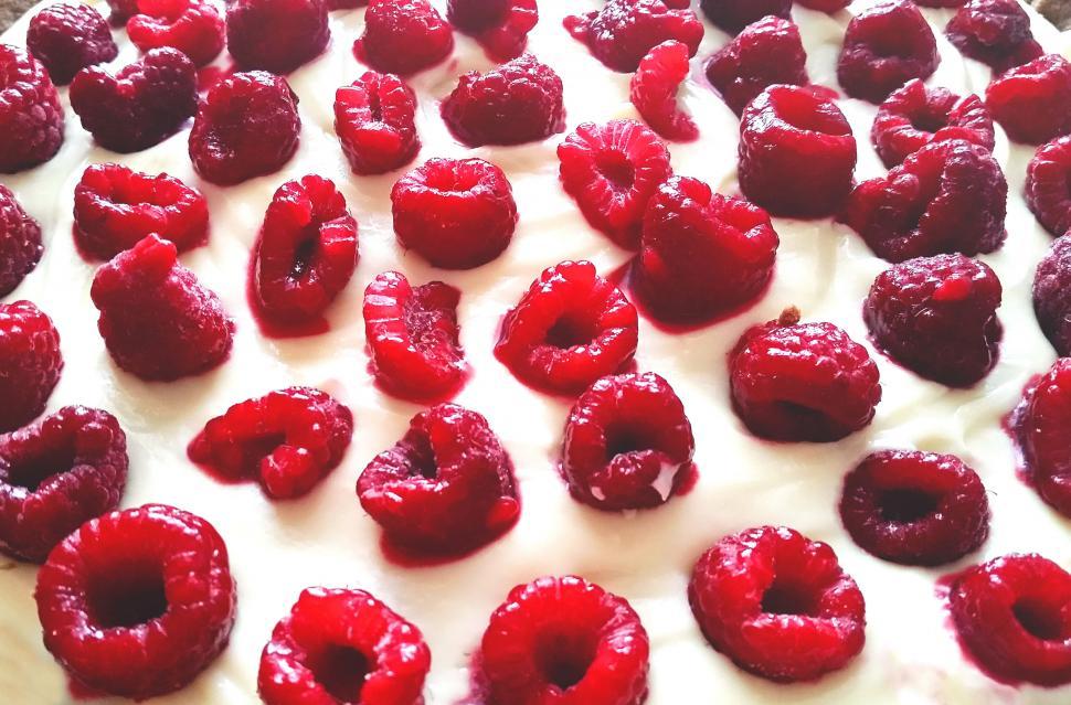 Free Image of Fresh raspberries on creamy cake top 
