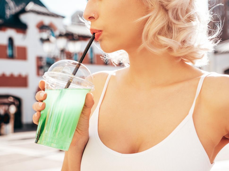 Free Image of A woman drinking from a straw 