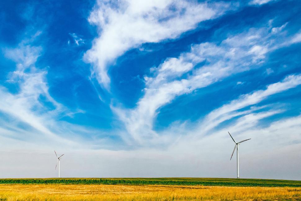 Free Image of Wind turbines against a sweeping cloudy sky 