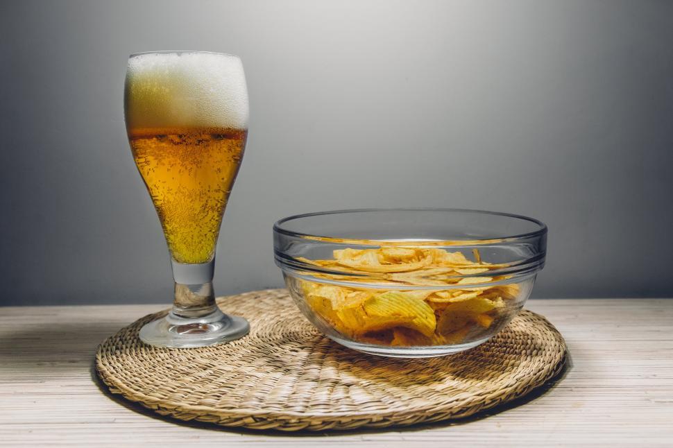 Free Image of Beer glass and bowl of chips on a place mat 