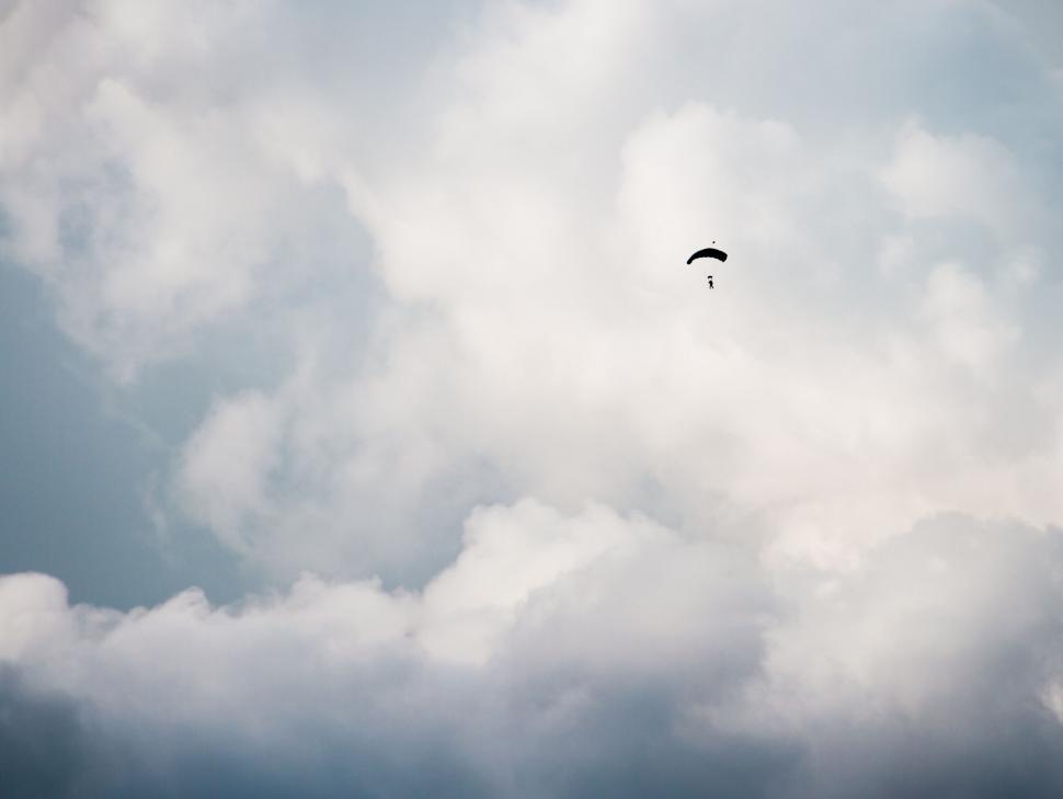 Free Image of Paraglider soaring in cloudy sky 