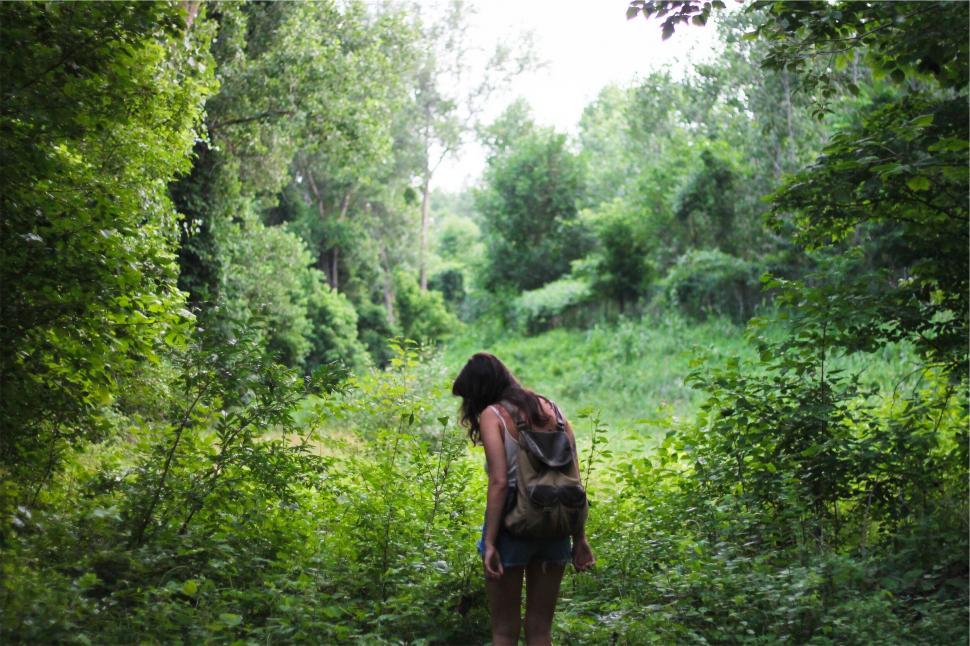 Free Image of Woman walking through a green forest 
