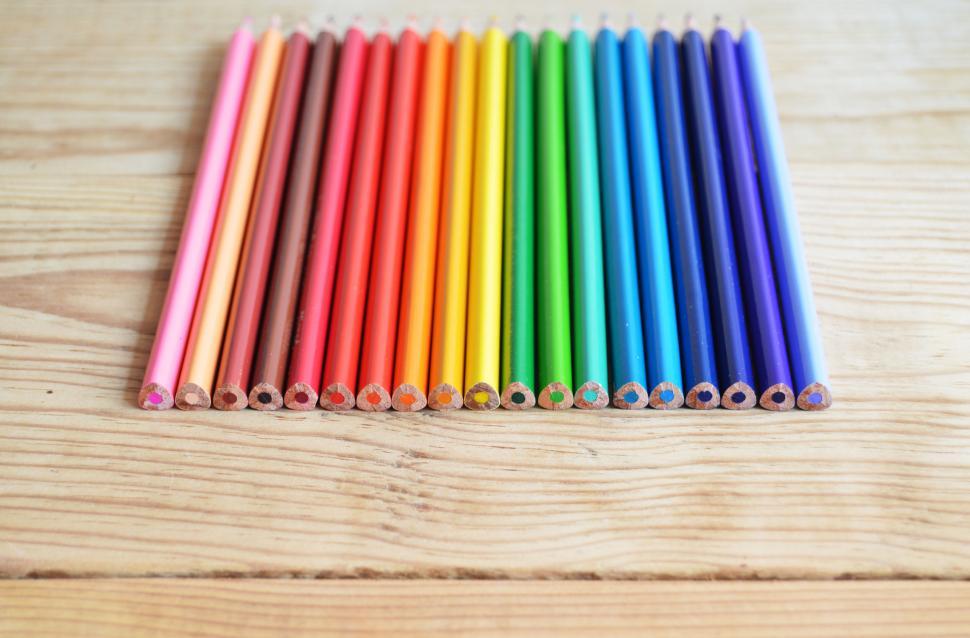 Free Image of Row of colored pencils on wooden background 