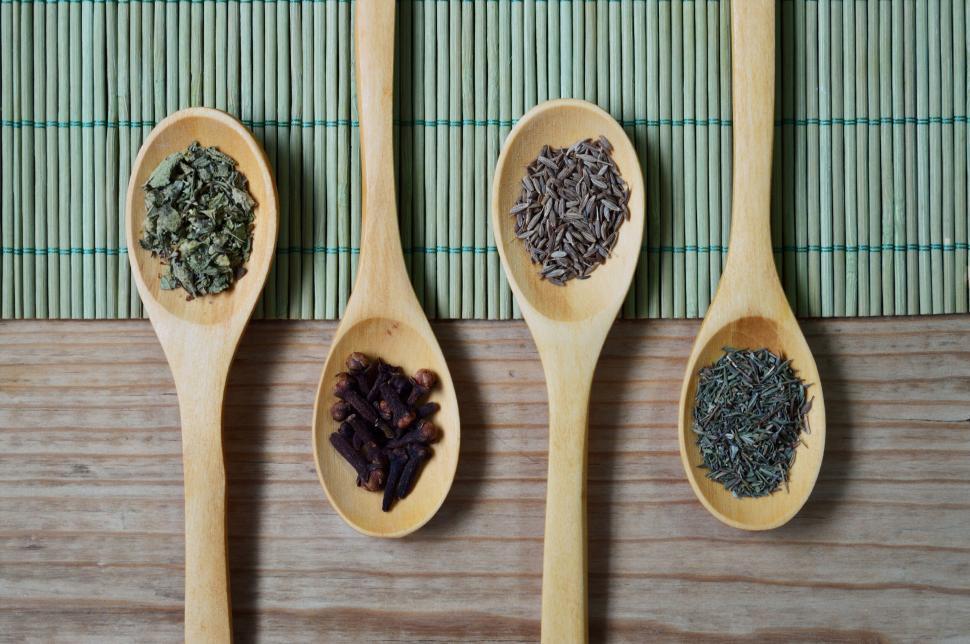 Free Image of Assortment of spices in wooden spoons on mat 