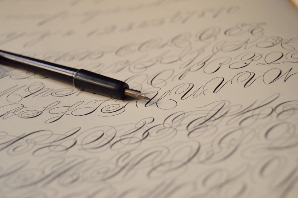 Free Image of Close-up of ink pen on calligraphy paper 