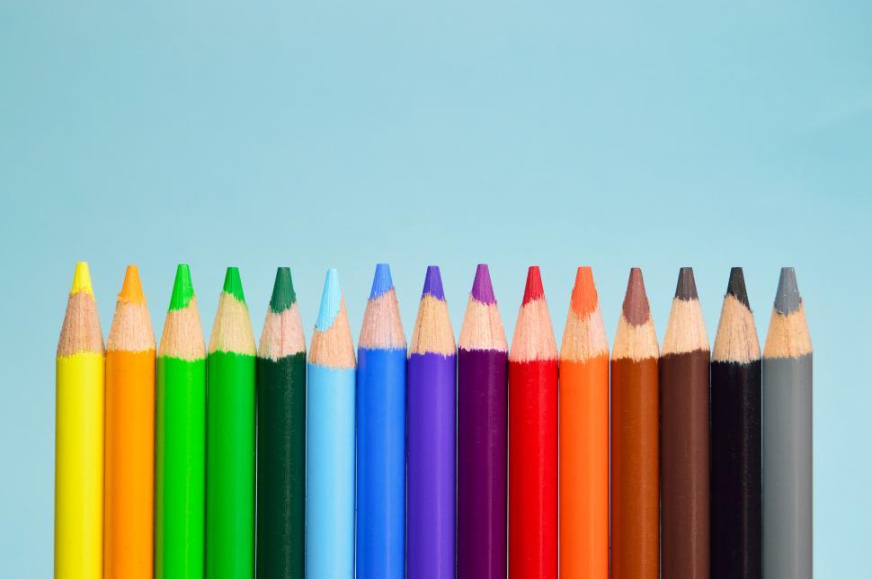 Free Image of Colorful pencils aligned on blue background 