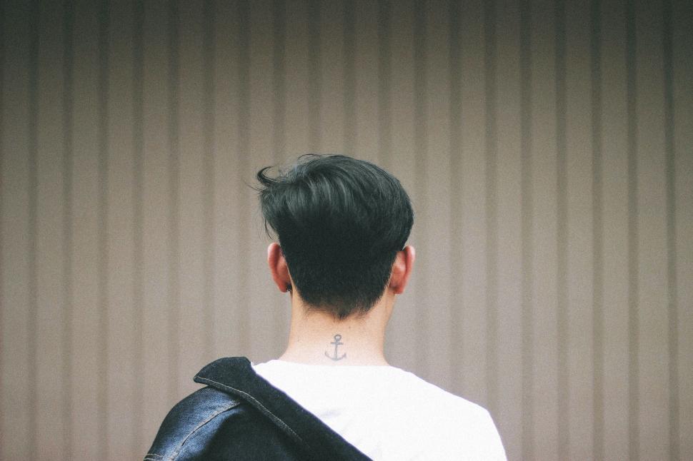 Free Image of Man with tattoo and modern hairstyle from back 