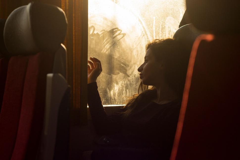 Free Image of Silhouette of a person looking out bus window 