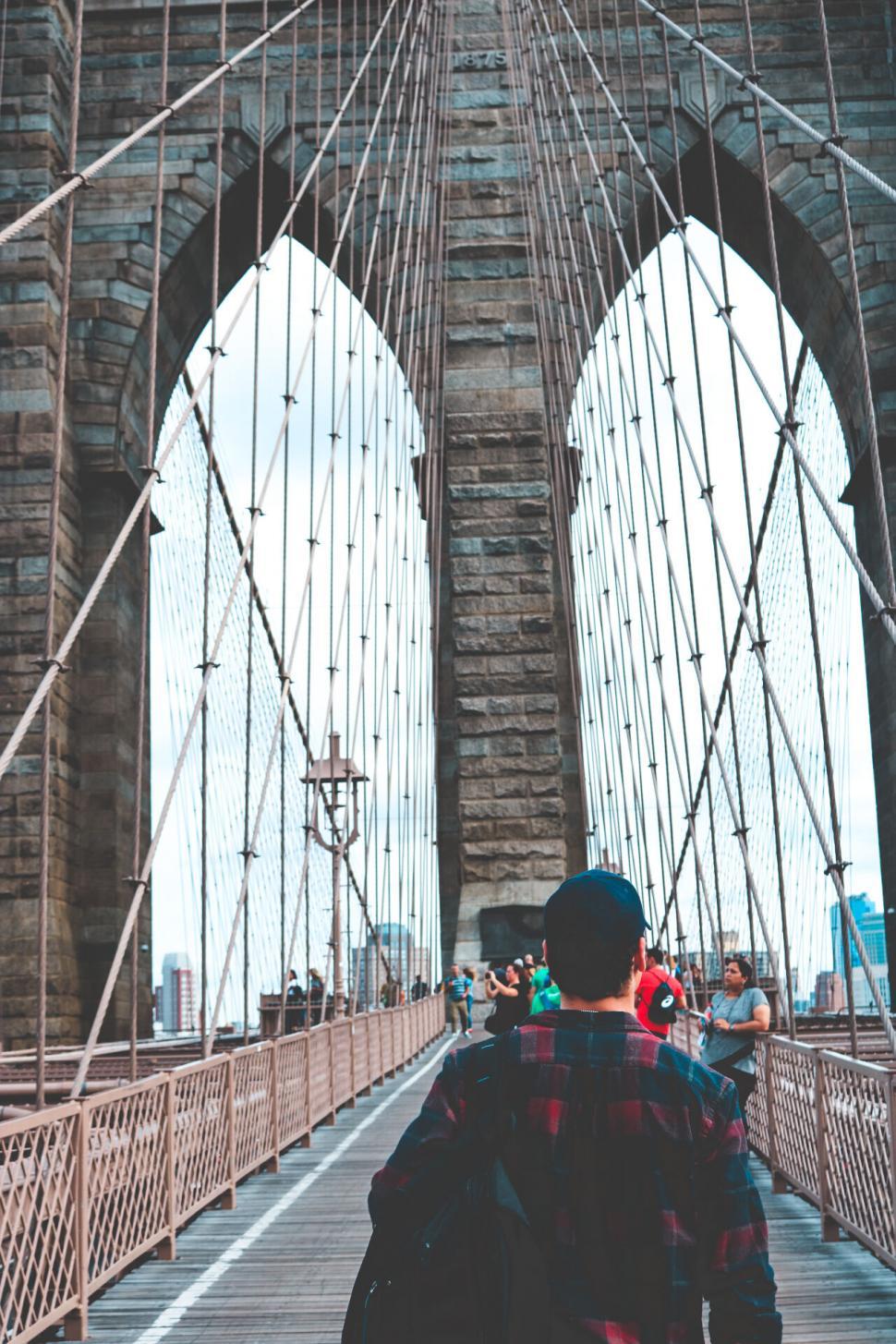 Free Image of Person walking on Brooklyn Bridge with others 