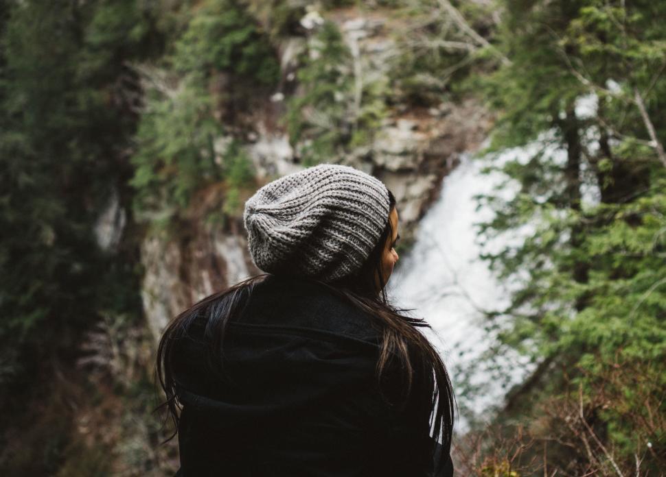 Free Image of Woman gazing at a waterfall in forest 