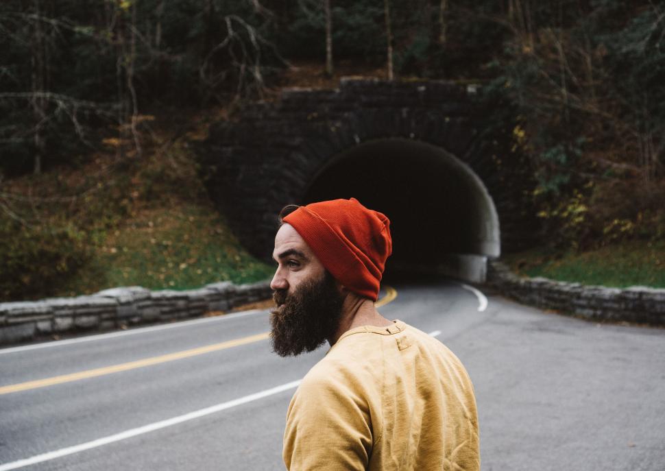 Free Image of Bearded man in red beanie by tunnel entrance 