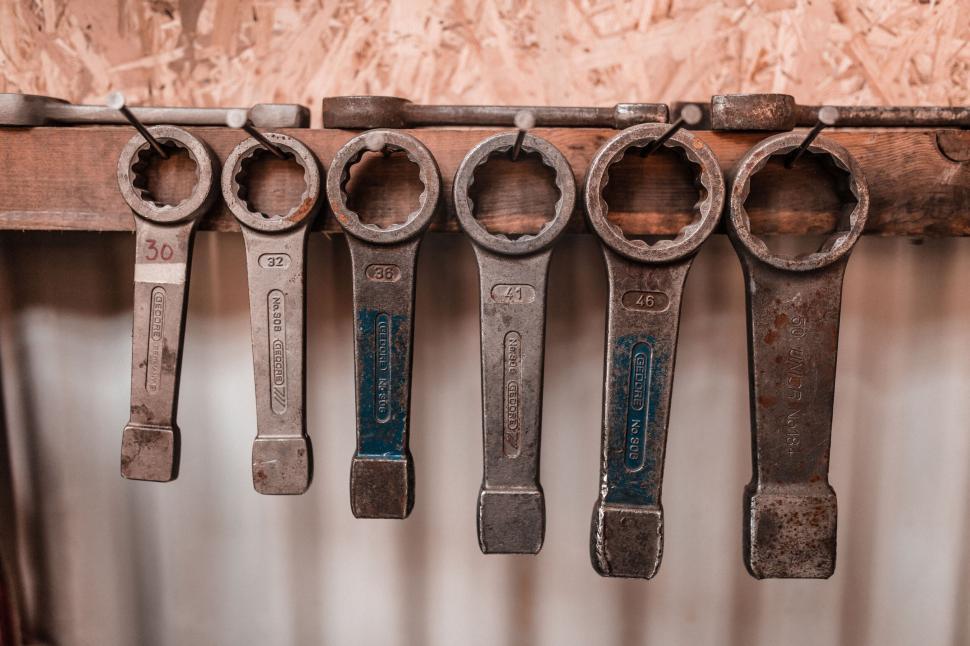 Free Image of Array of rusted metal wrenches on a board 