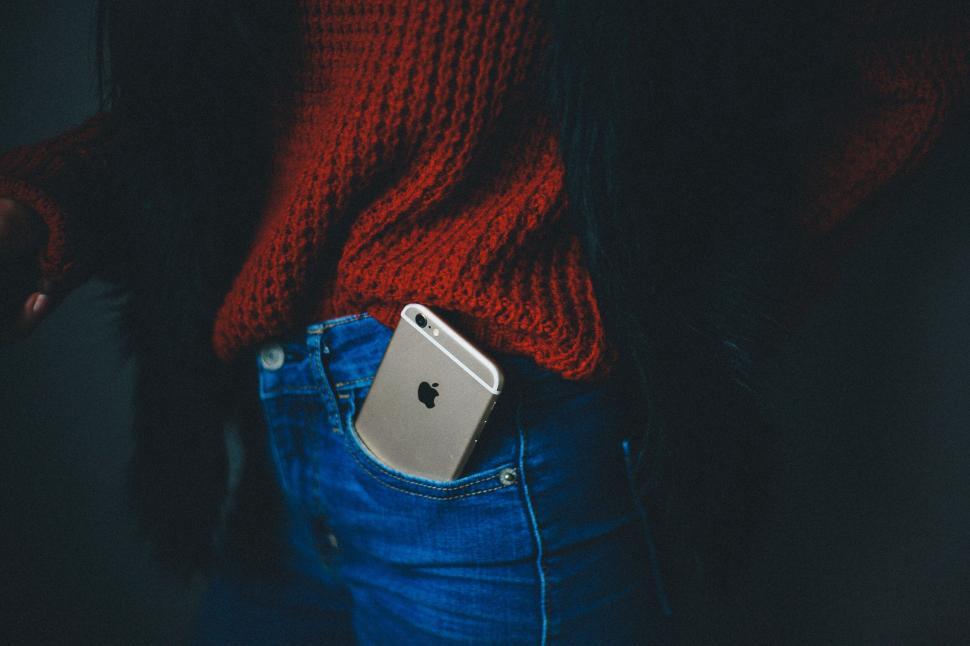 Free Image of Apple phone in the pocket of jeans with red sweater 