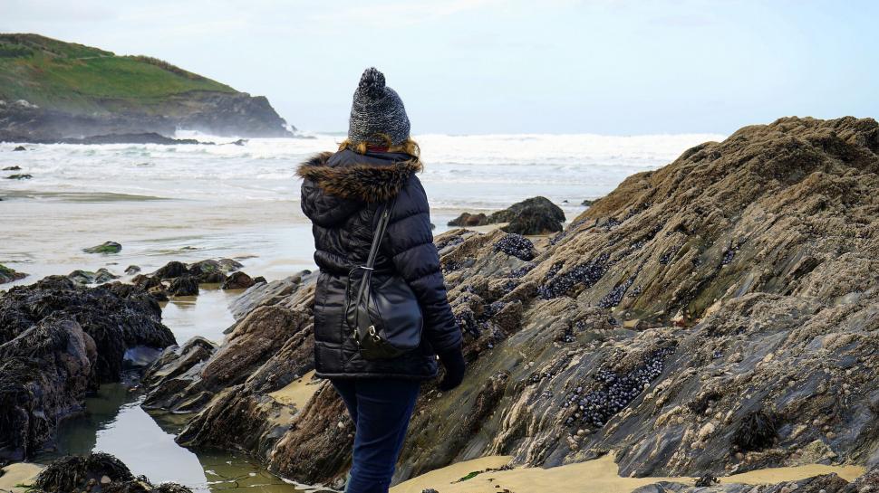 Free Image of Person wearing a backpack at rocky coastline 