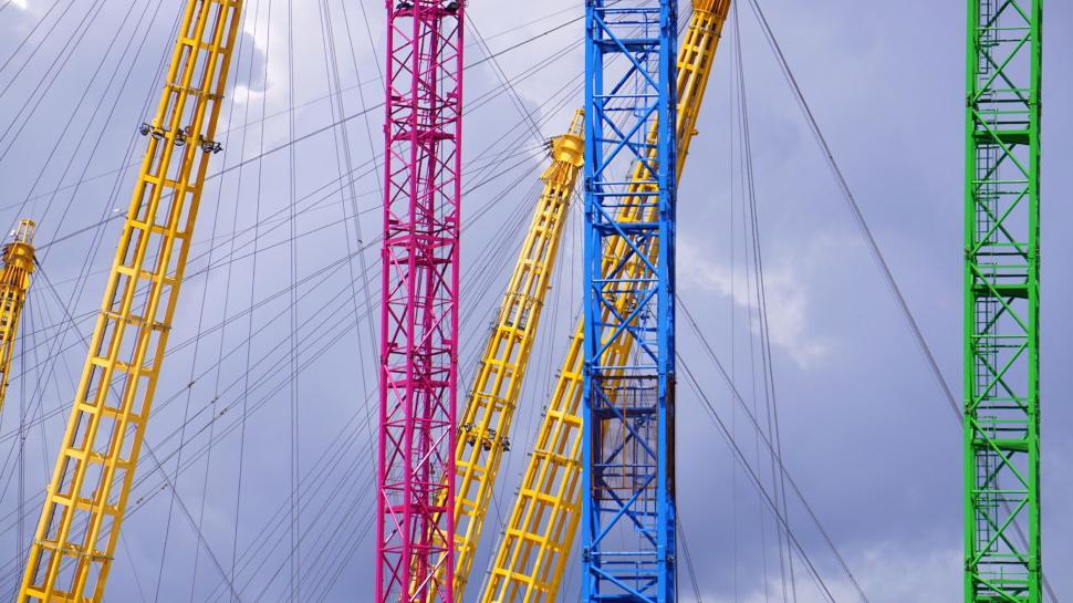 Free Image of Colorful cranes against a cloudy sky 