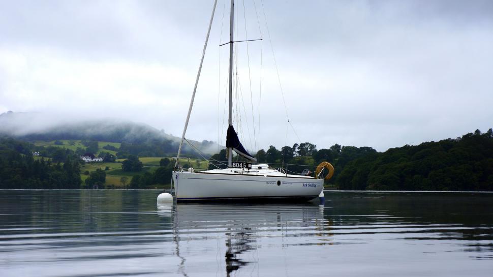 Free Image of Sailboat anchored on a calm lake 
