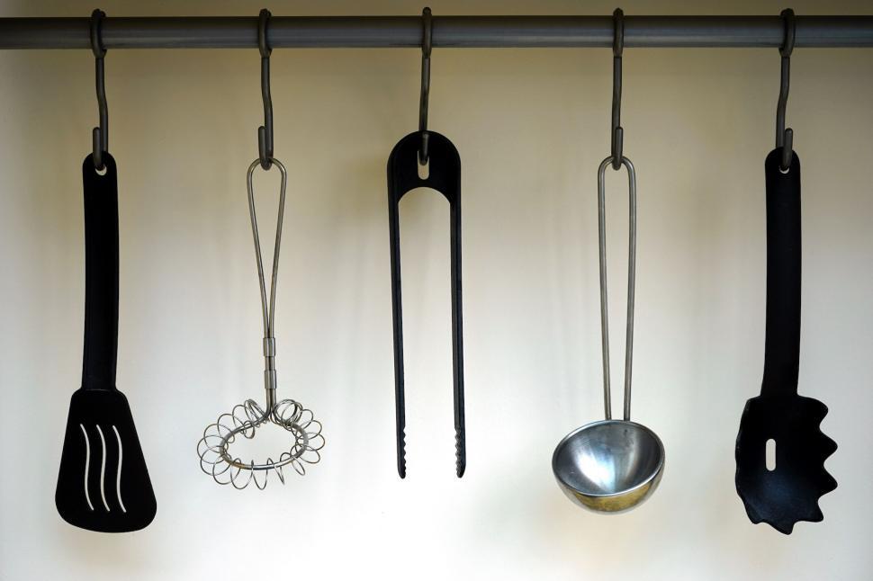 Free Image of Kitchen utensils hanging on a modern rail 