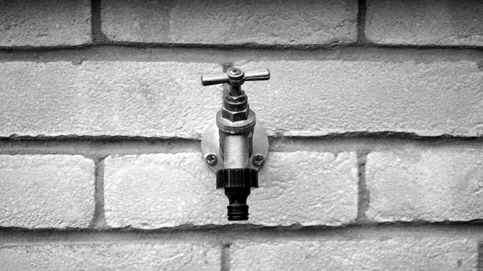 Free Image of Black and white photo of an outdoor wall tap 