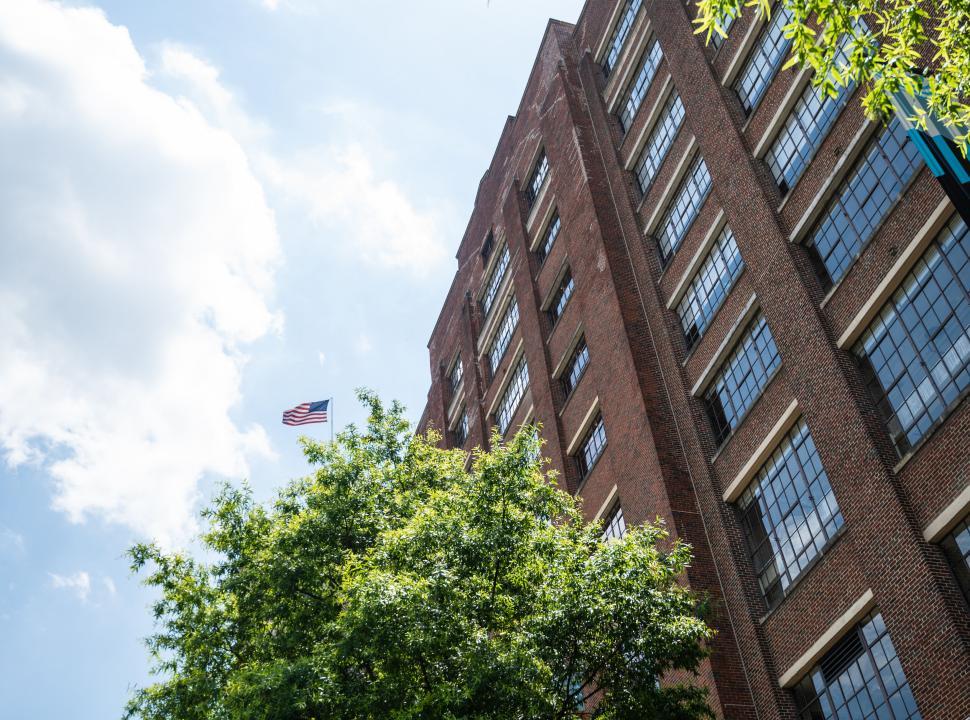 Free Image of American flag atop a traditional brick building 
