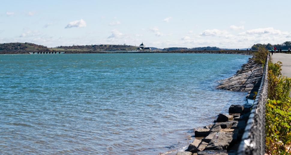 Free Image of Calm coastal view with a distant lighthouse 