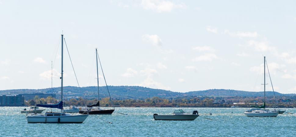 Free Image of Calm lake scene with sailboats and hills 