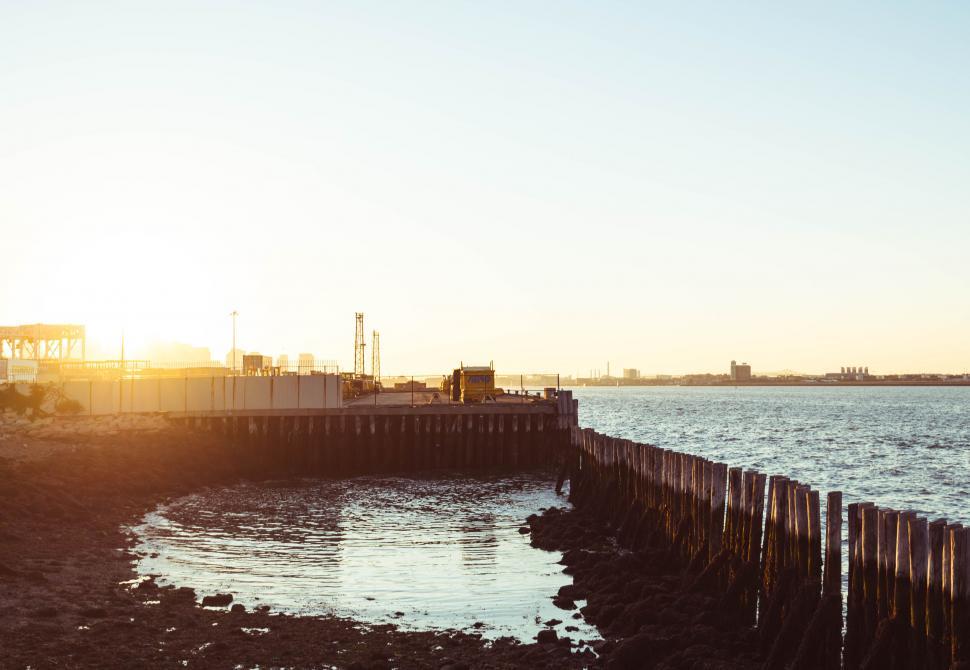 Free Image of Pier at Sunset with City Skyline in the Background 