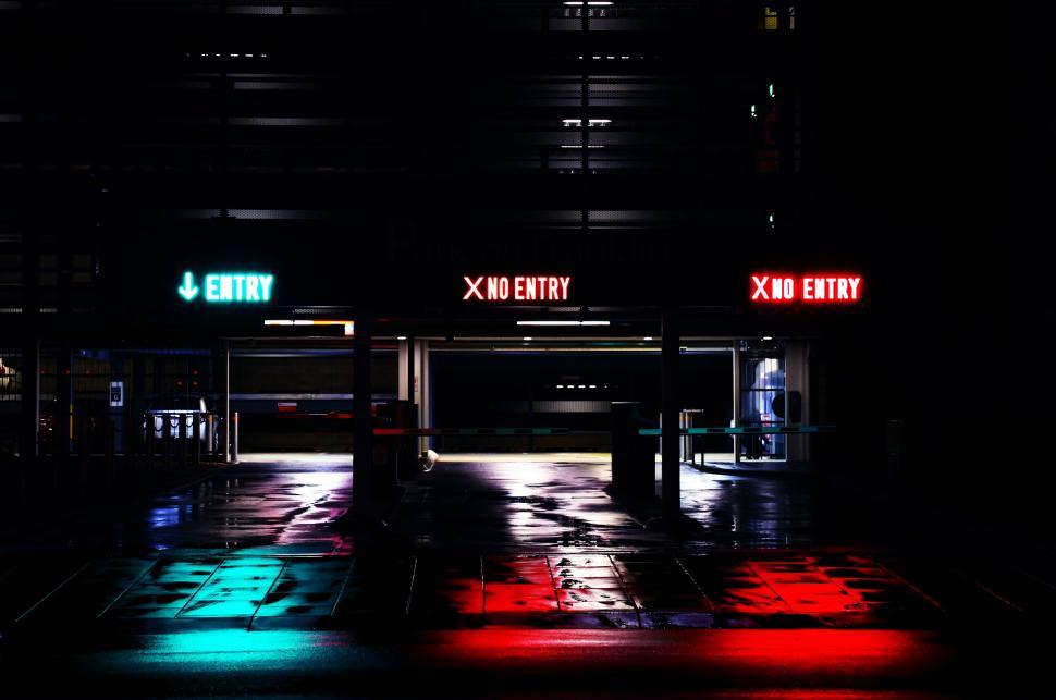 Free Image of Neon Entry signs in dark empty garage 