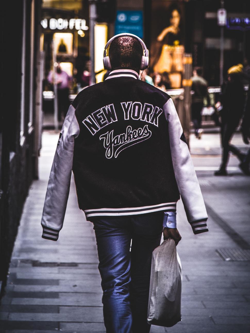 Free Image of Man in New York Yankees jacket walking 