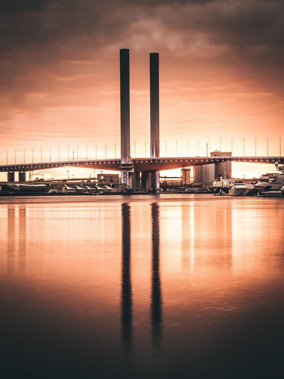 Free Image of Sunset over a bridge and reflecting water 