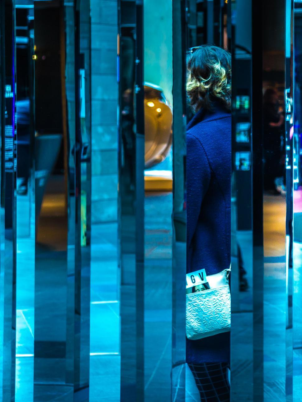 Free Image of Woman reflected in a vibrant blue glass 
