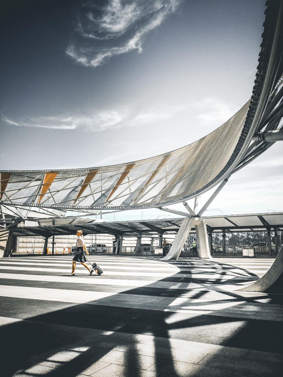 Free Image of Woman walking in sunlight at modern station 