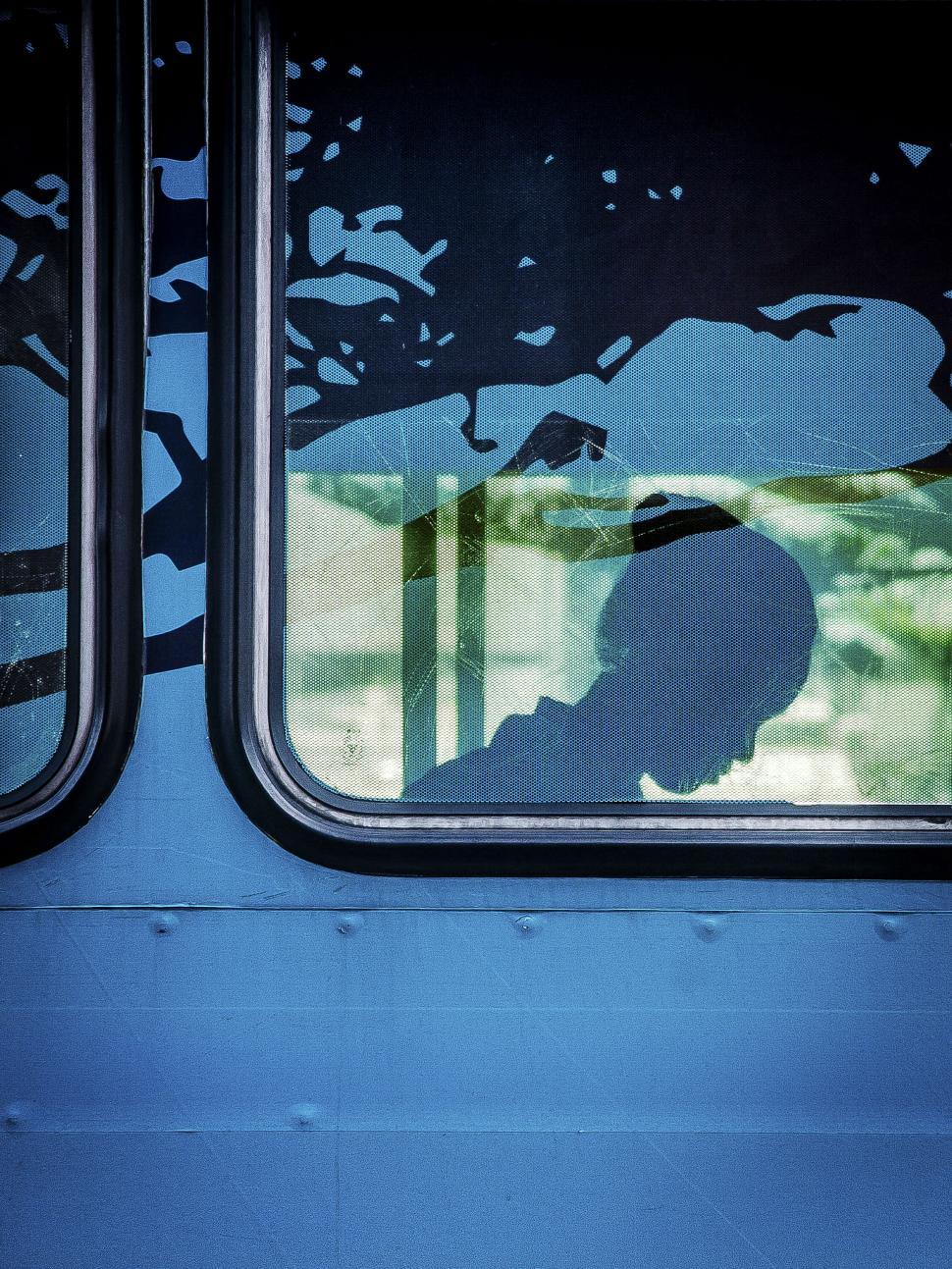 Free Image of Silhouette in Window of Blue Vehicle 