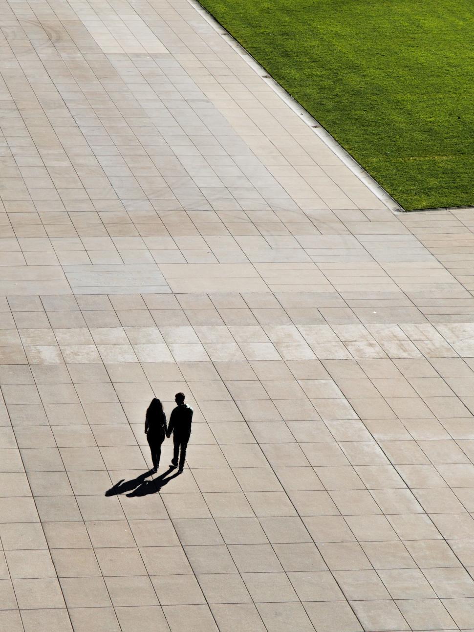 Free Image of Aerial view of two people walking on pavement 