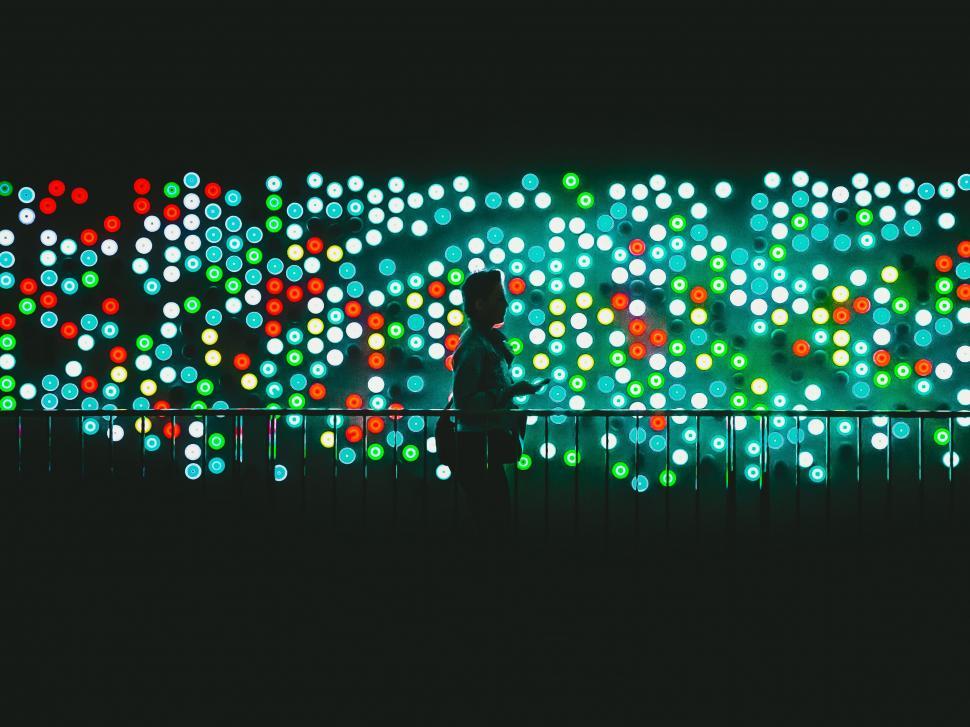 Free Image of Person silhouette against colorful light dots 