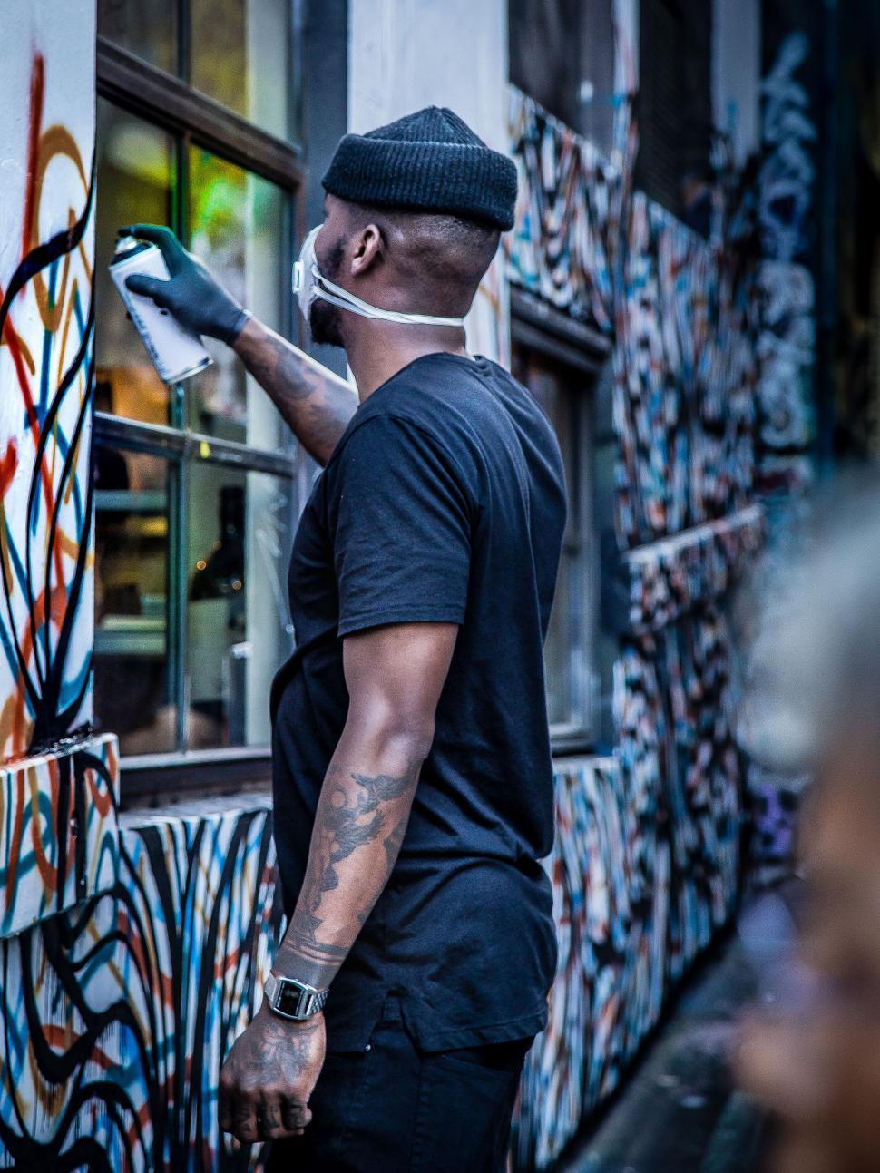 Free Image of Urban artist painting a colorful mural 