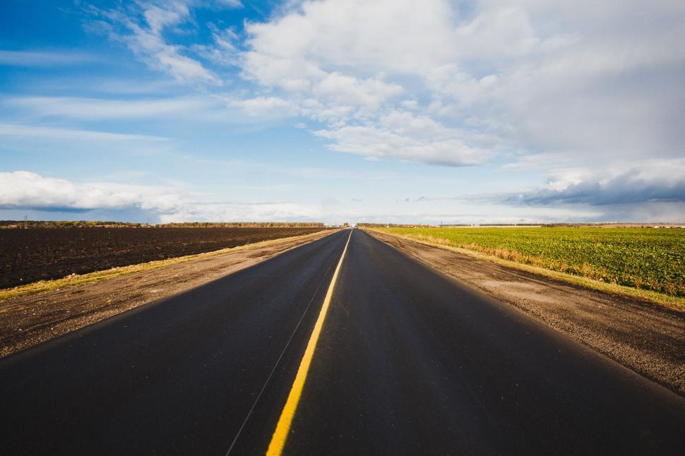 Free Image of Open road under a vast sky with clouds 