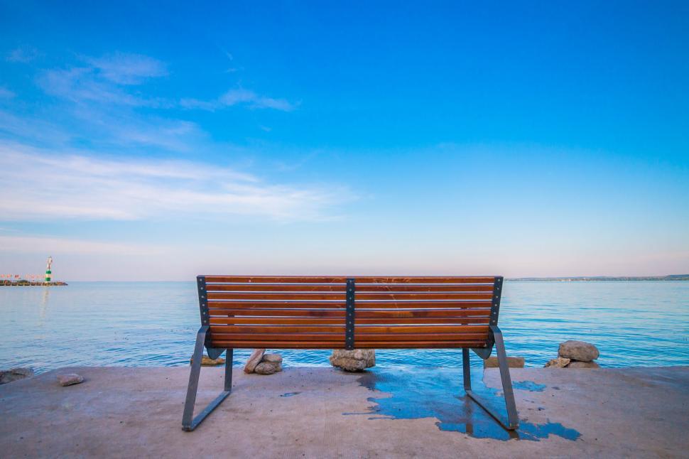 Free Image of Empty bench overlooking calm sea 