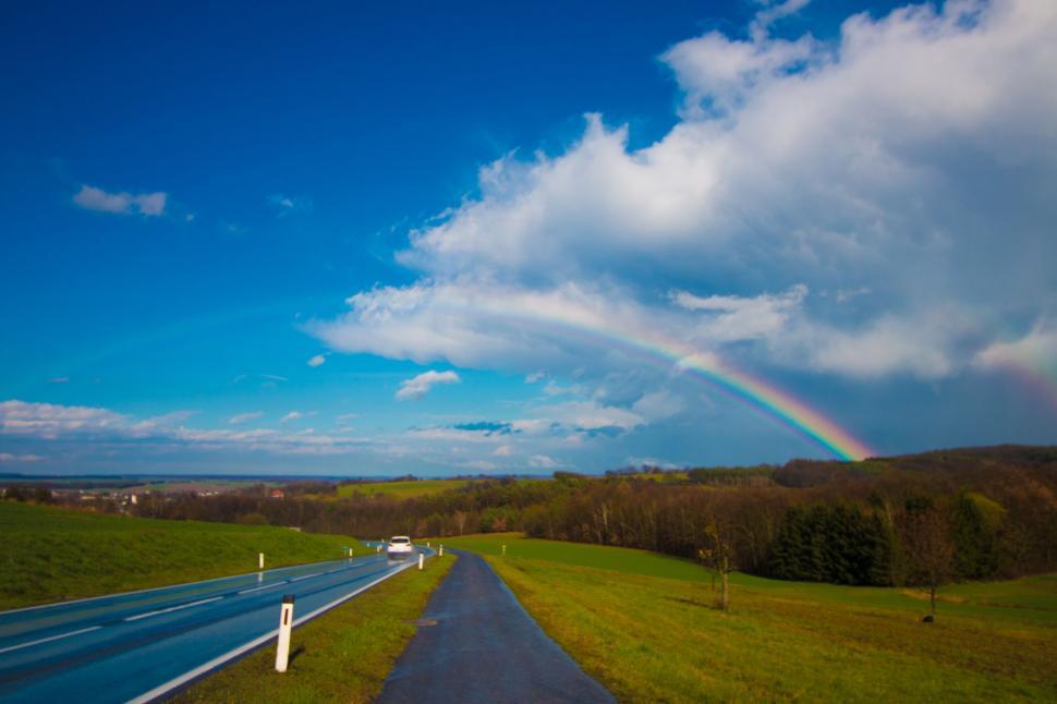 Free Image of Rainbow over a rural landscape road 