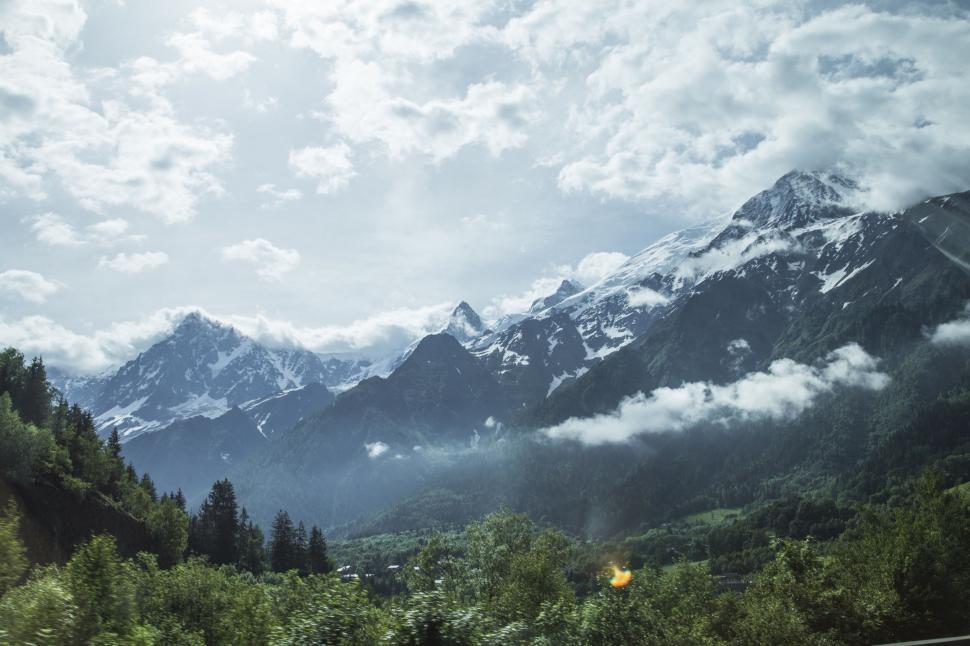 Free Image of Snow-capped mountains under a cloudy sky 