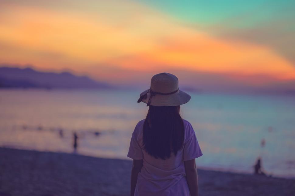 Free Image of Woman watching sunset on the beach 