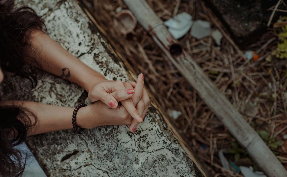 Free Image of Intertwined hands with tattooed wrist 
