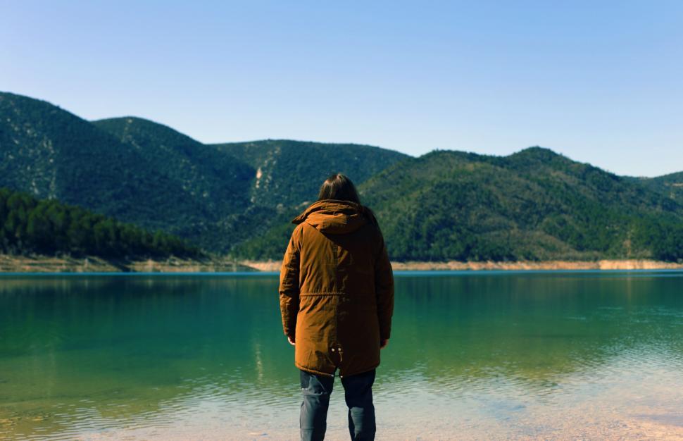 Free Image of Man looking at lake with mountains reflection 