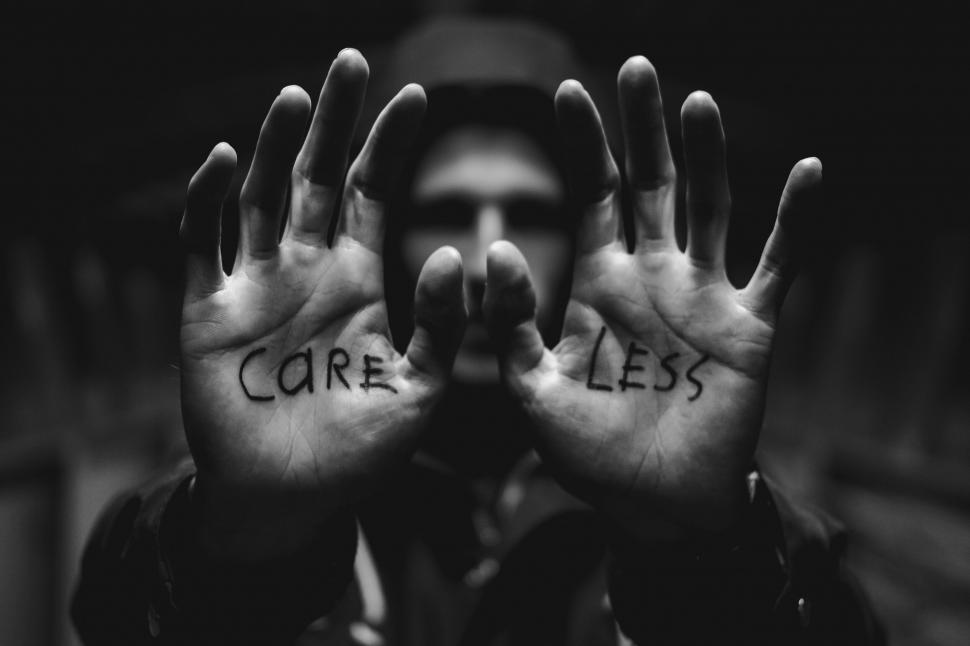 Free Image of Man with  CARE LESS  written on palms 