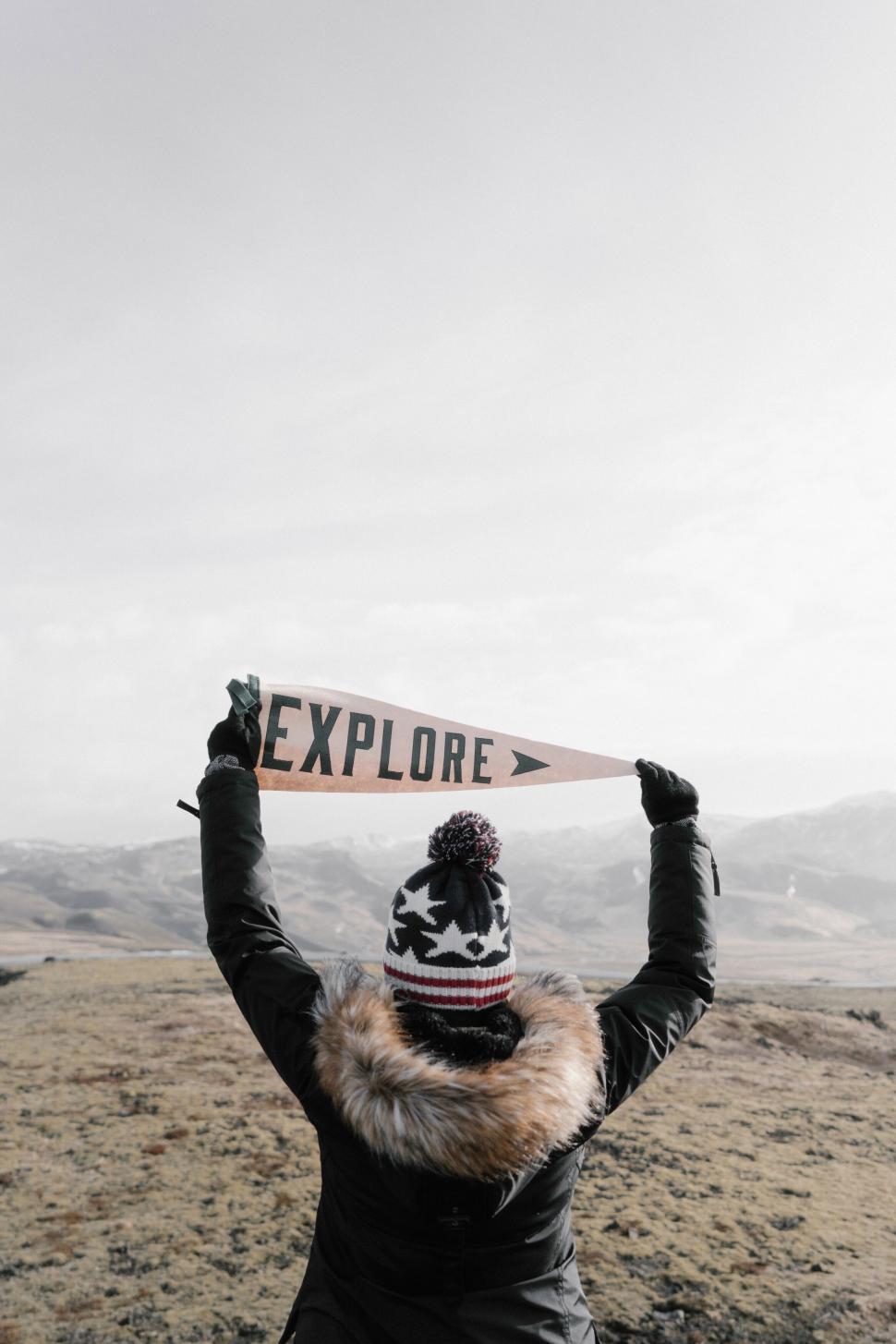 Free Image of Person holding an  EXPLORE  sign outdoor 