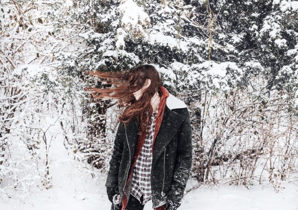 Free Image of Woman enjoying snowfall in the woods 